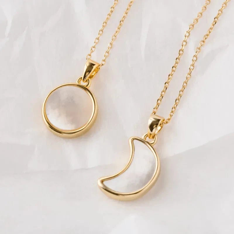 Two gold necklaces with circular and crescent moon pendants on a white background