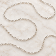 Sterling silver cable chain coiled on marble — add a chain to any Mystic Soul pendant