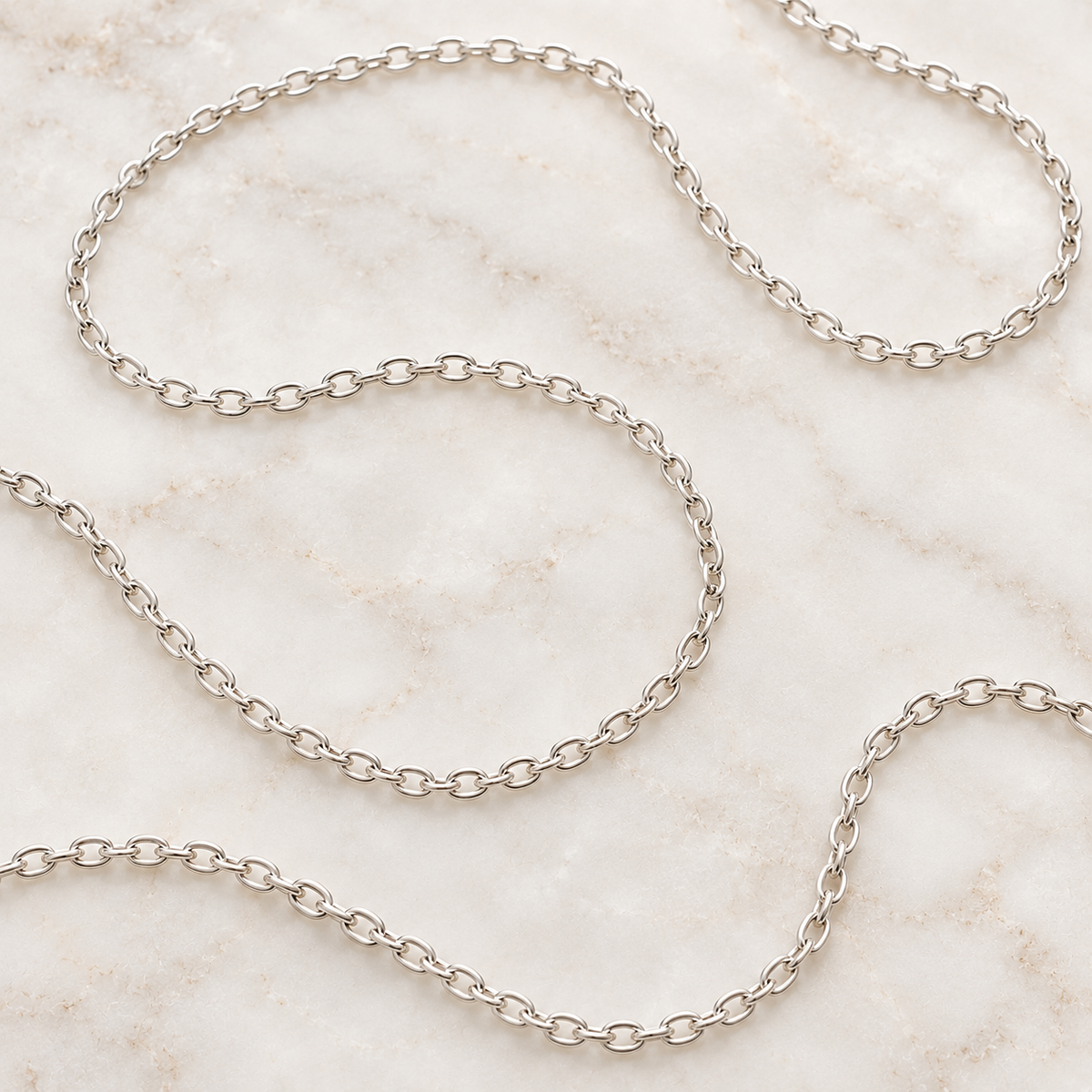 Sterling silver cable chain coiled on marble — add a chain to any Mystic Soul pendant