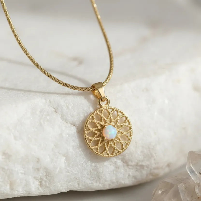 opal mini medallion gold necklace with a circular pendant featuring an opal stone on a marble surface.