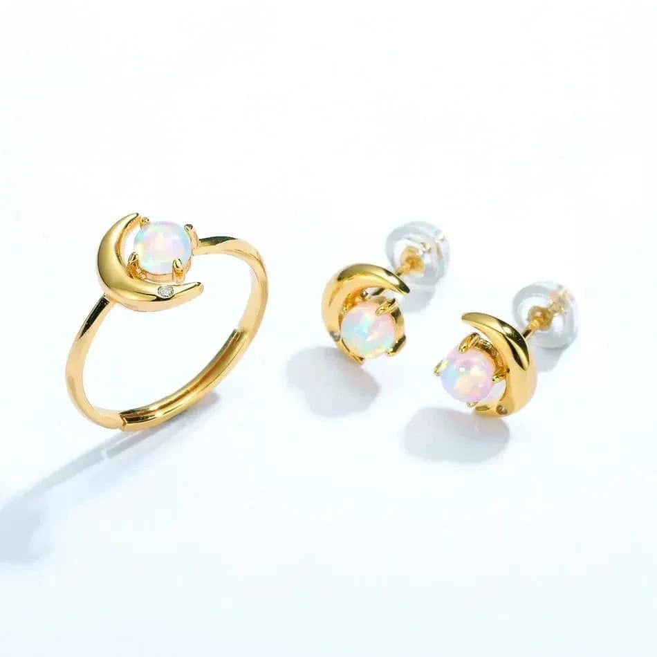 Gold ring and earrings with opal stones on a white background