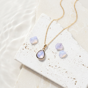Gold teardrop necklace with iridescent opalite glass pendant, opal-inspired October birthstone colour