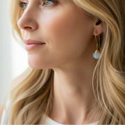opalite gold earrings with gemstones on a white surface with crystals