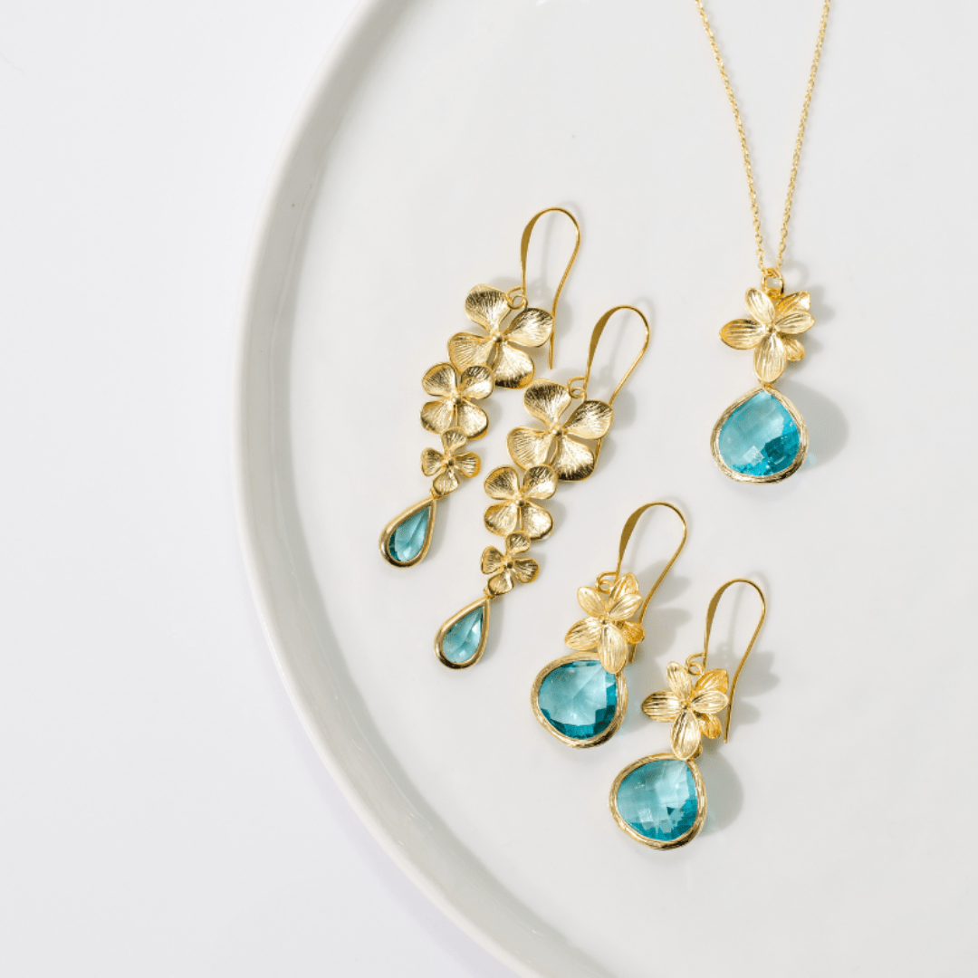 Gold and turquoise jewelry set on a white background