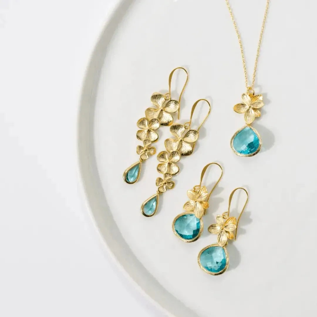Gold and turquoise jewelry set on a white background