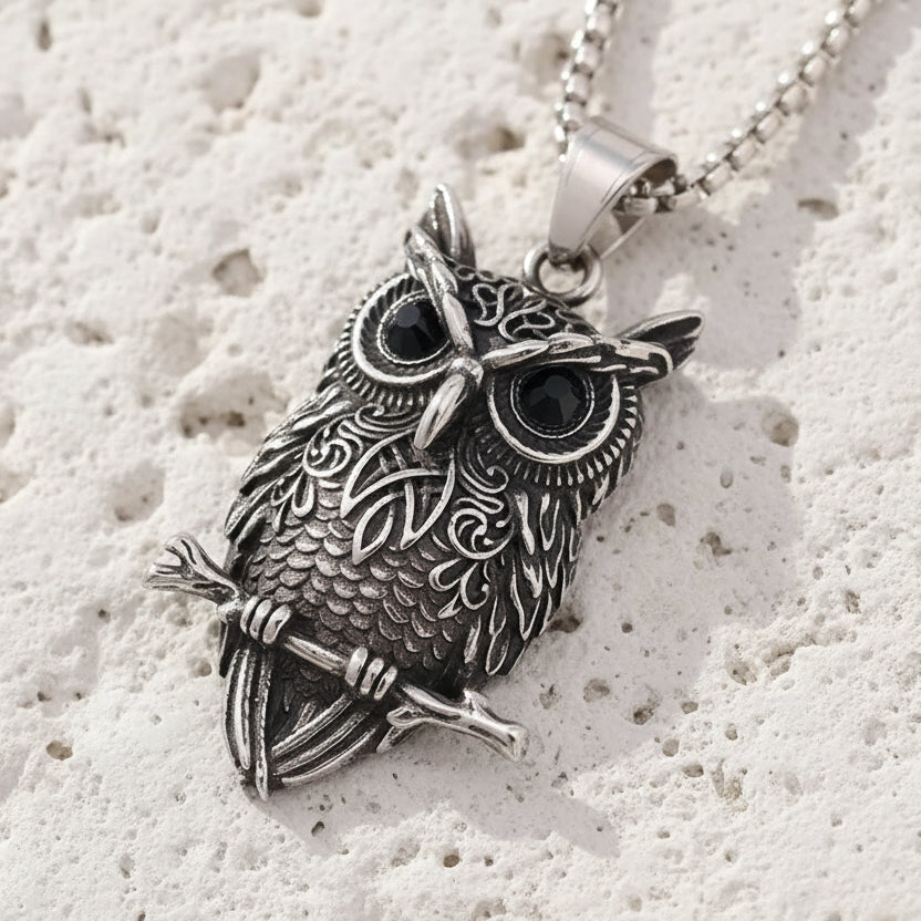 Silver owl pendant necklace on a brown leather background