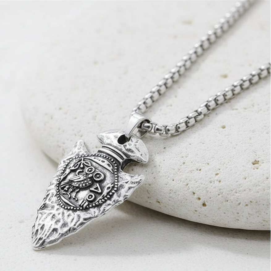 Silver owl pendant on a chain on white background