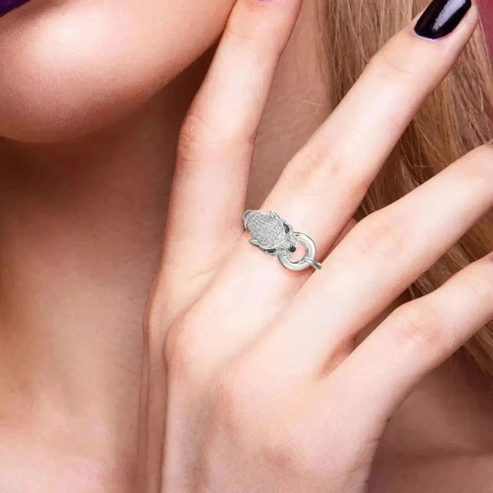 Silver ring with intricate design on a finger