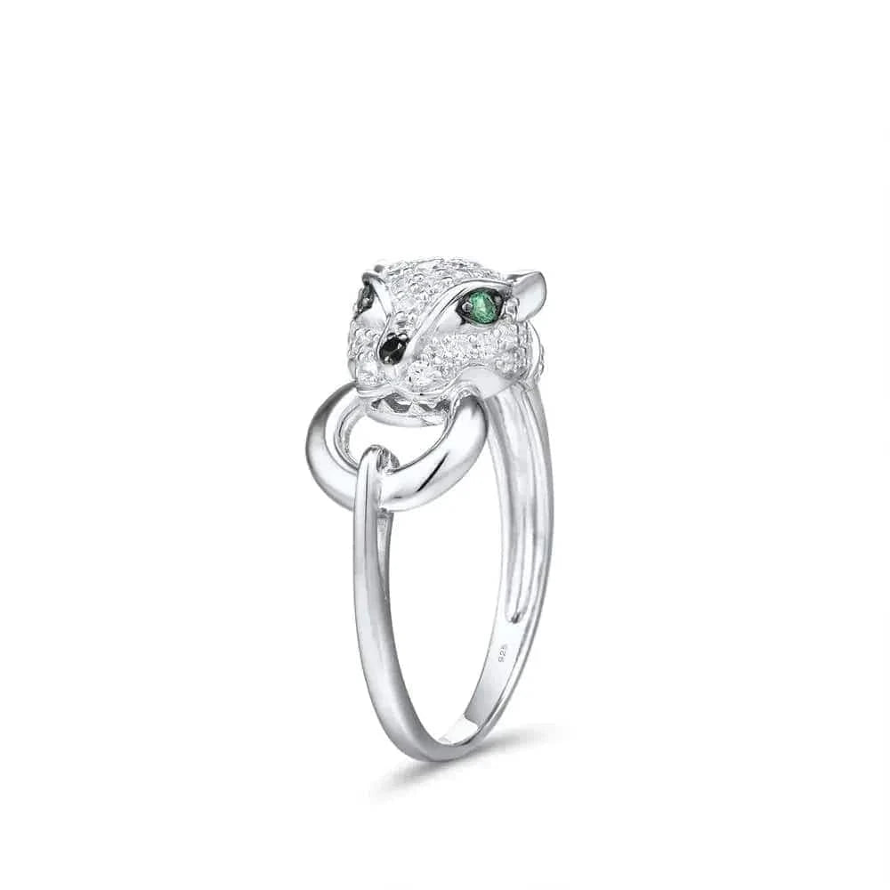 Silver ring with a panther head design and green gemstones on a white side angle