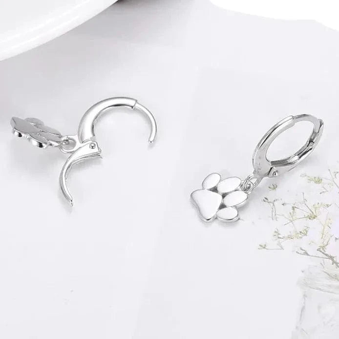 Silver hoop earrings with heart charms on a white surface