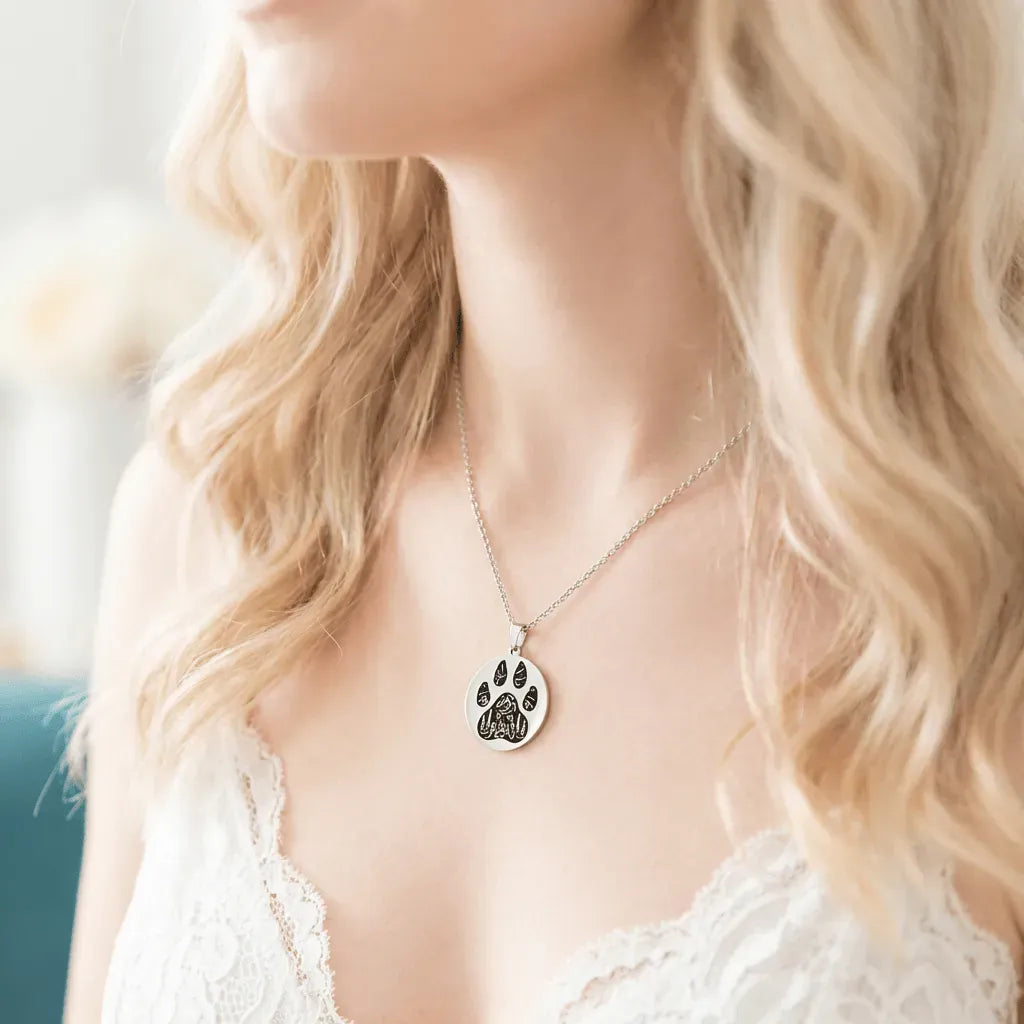 Person wearing a necklace with a paw print pendant