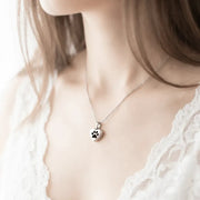 Woman wearing a silver paw print memorial necklace — keepsake necklace for remembrance
