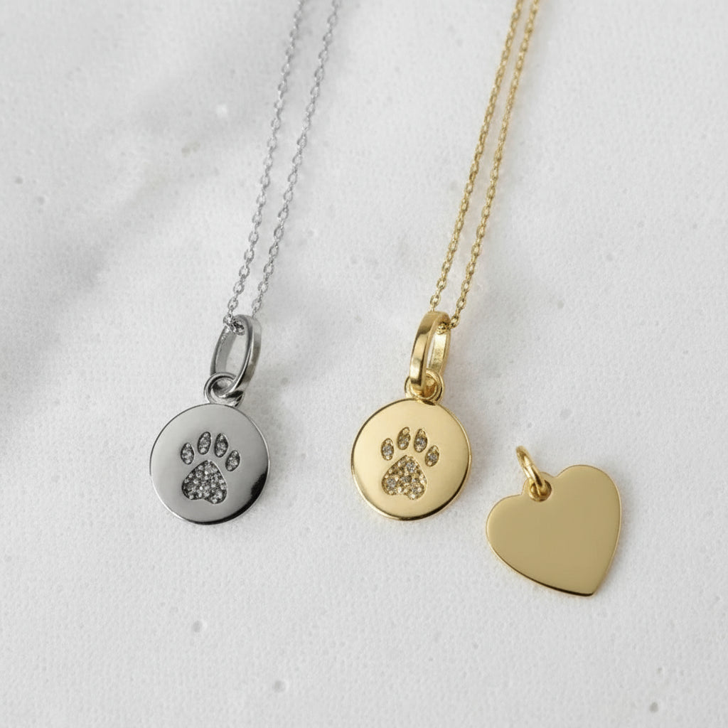 Two necklaces with paw print pendants on a white background