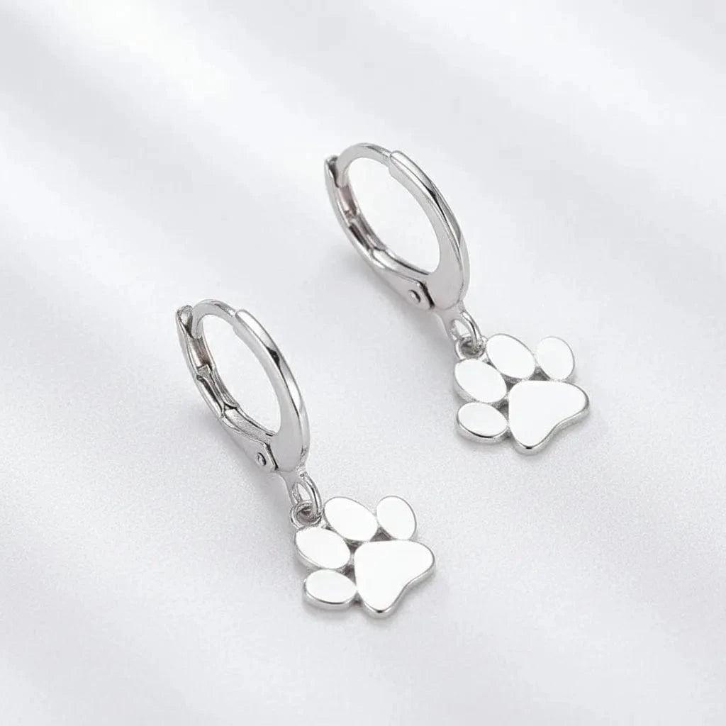 Silver paw print earrings on a white background with text
