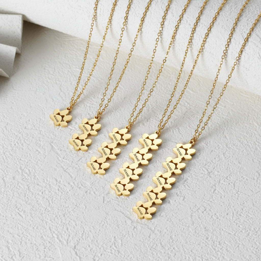 Gold necklaces with floral pendants on a green background
