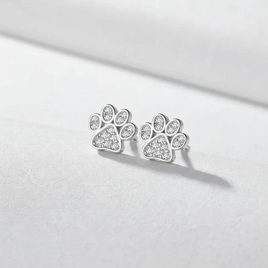 Paw print earrings on a blue background