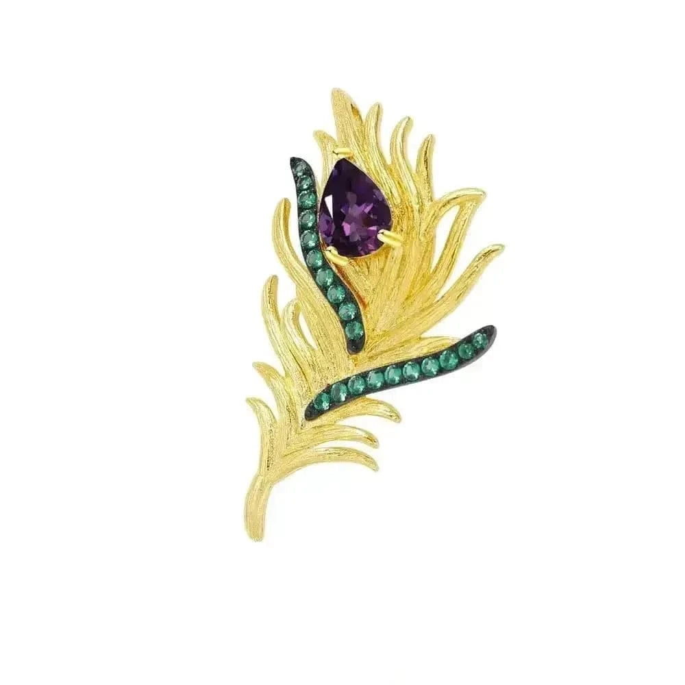 Gold brooch with purple and green gemstones on a white background