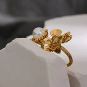 Gold ring with a pearl on a white surface, 