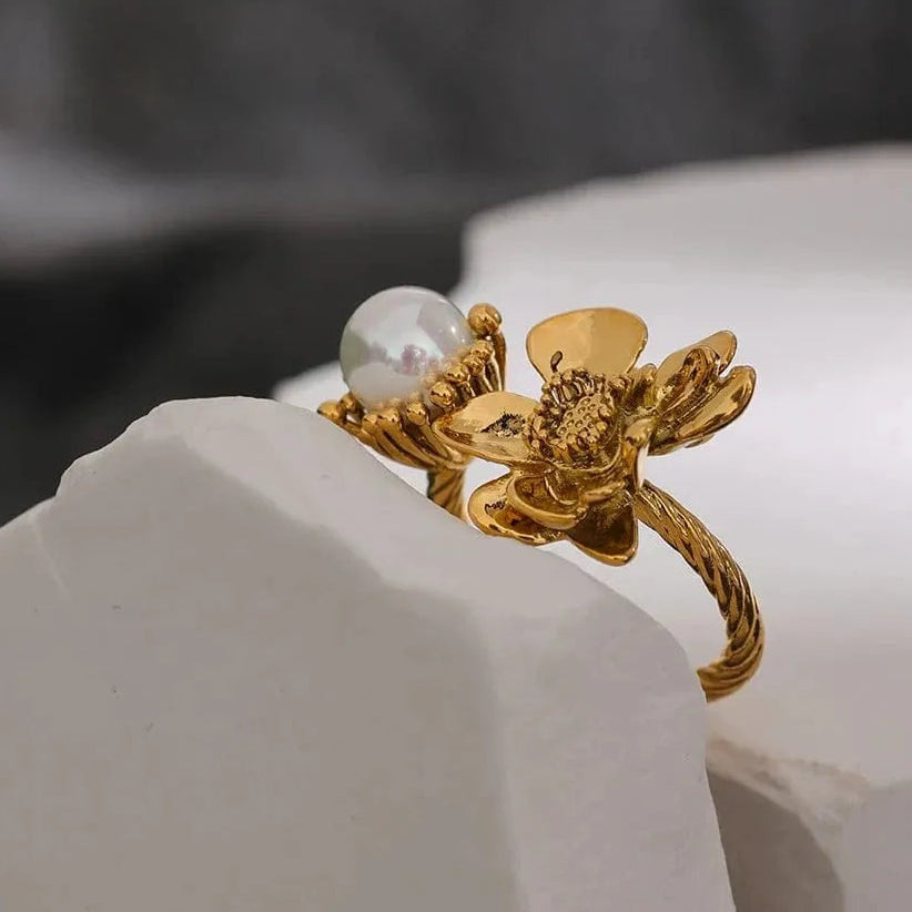 Gold ring with a pearl on a white surface, 