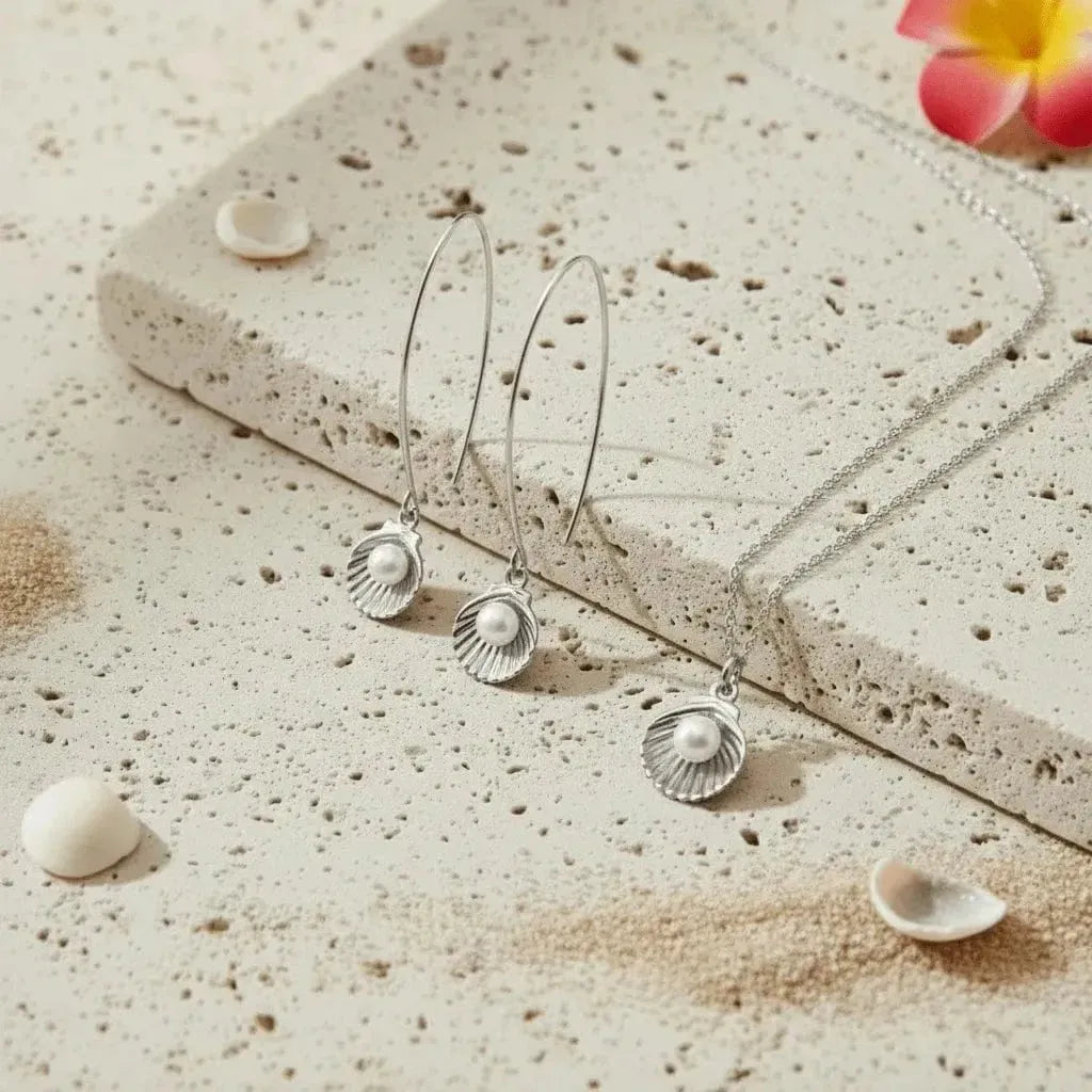 Gold jewelry set with pearls on a textured stone surface