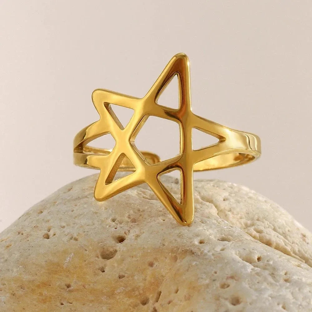 Gold star-shaped ring on a beige stone