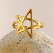 Gold star-shaped ring on a beige stone