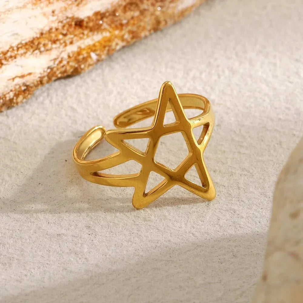 Gold star-shaped ring on a textured beige surface