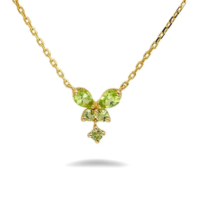 Gold necklace with green gemstones on a white background