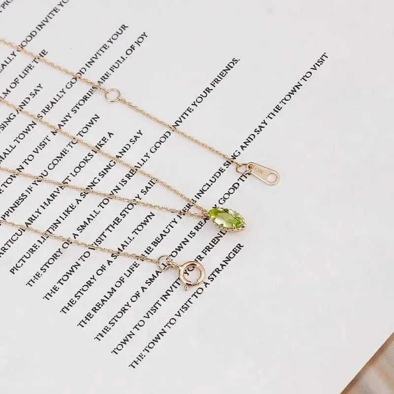 Gold necklaces with green gemstones on a text background