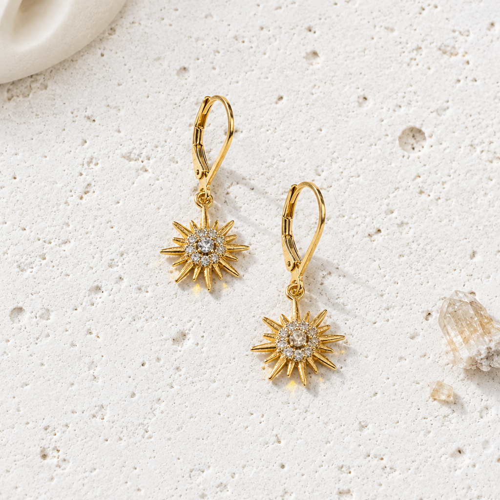 Gold plated petite star drop earrings with a single CZ and halo on leverbacks