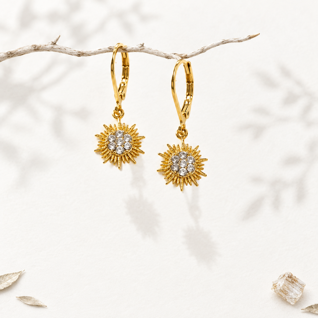 Petite gold sun drop earrings with CZ cluster hanging from a branch
