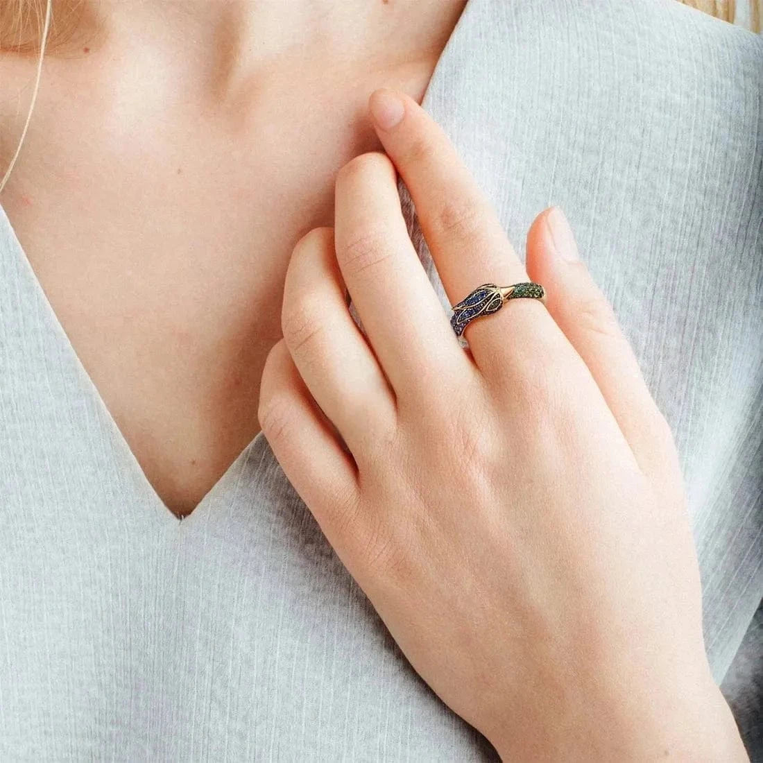 Close-up of a hand wearing a ring with a light background