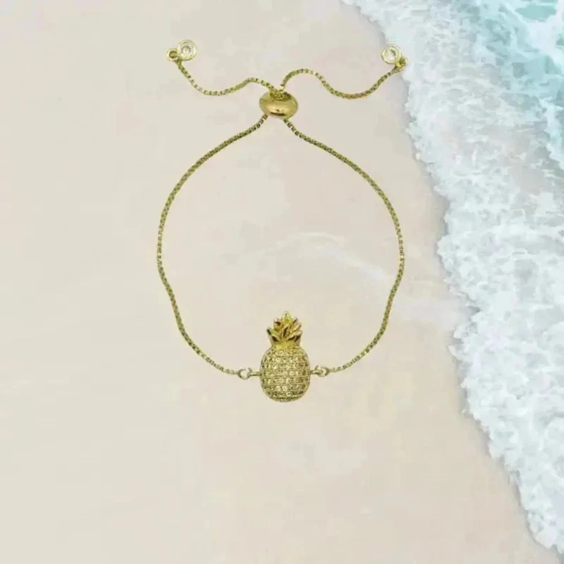 crystal pineapple bracelet in gold with beach in background