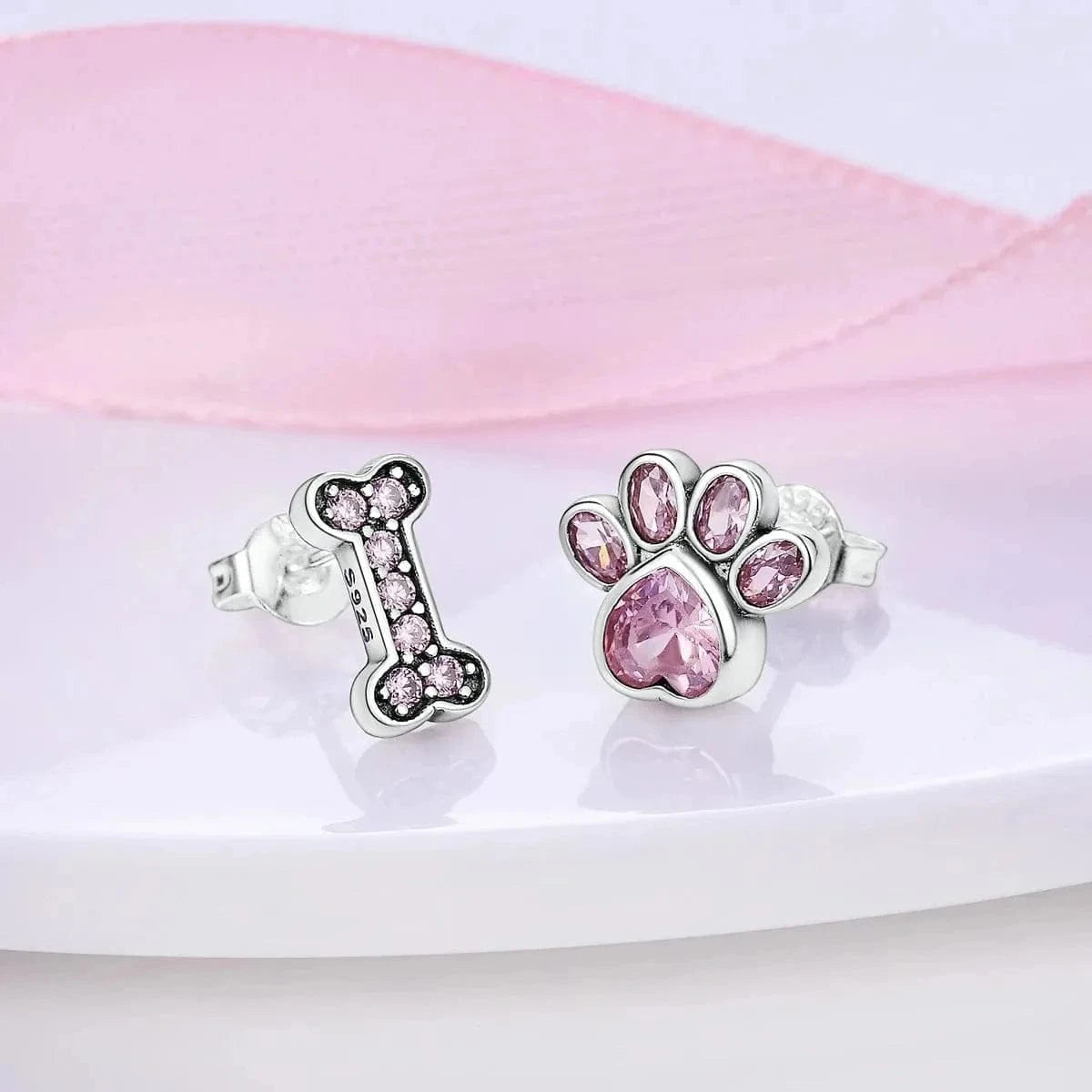 Pair of earrings with pink gemstones on a white surface