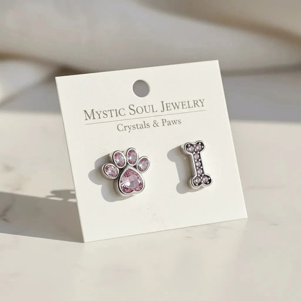 Pair of paw and bone-shaped earrings on a 'Mystic Soul Jewelry' card.