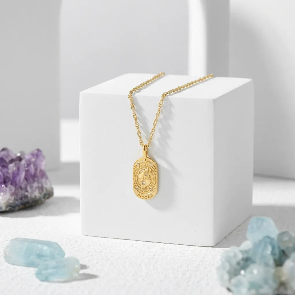 Gold necklace with a pendant on a white block, surrounded by crystals