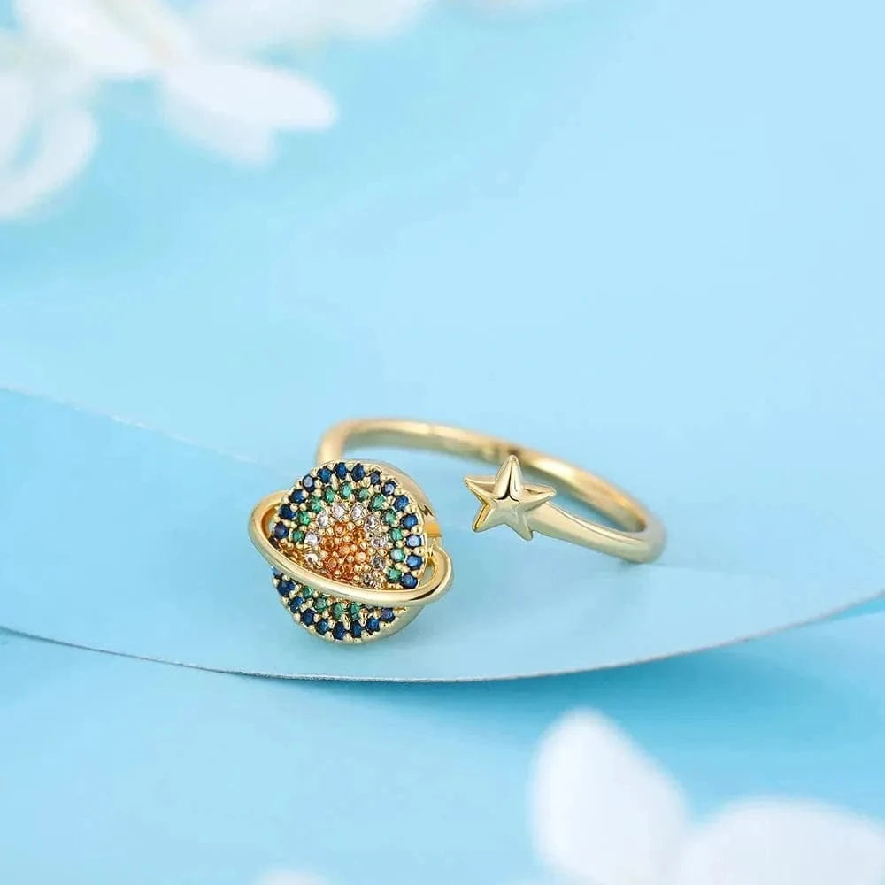 Gold ring with gemstones and a star on a light blue background