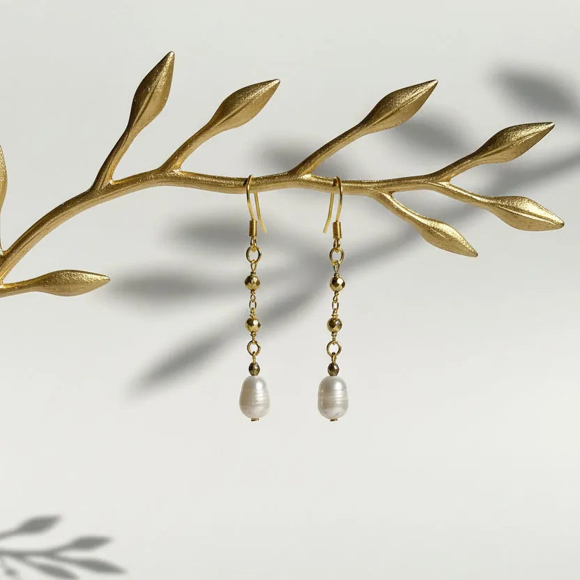 Close-up of gold pyrite chain earring with freshwater potato pearl drop, June birthstone jewelry