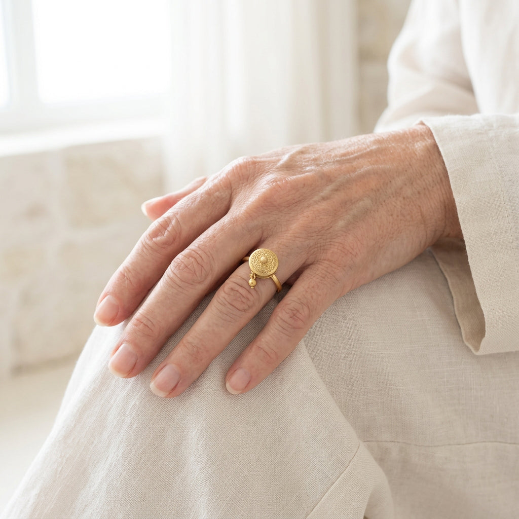 Hand wearing a gold-plated prayer wheel spinner ring, meditation ring you can turn