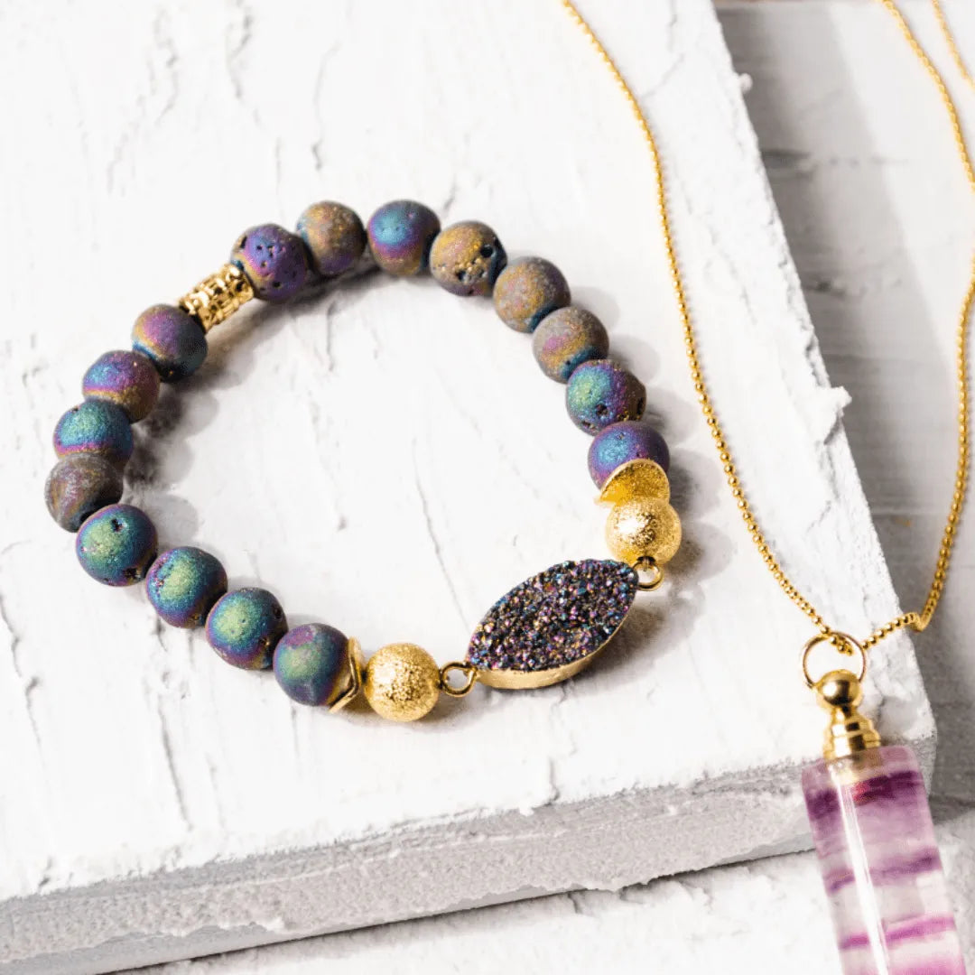 Bracelet with purple and gold beads on a textured white surface