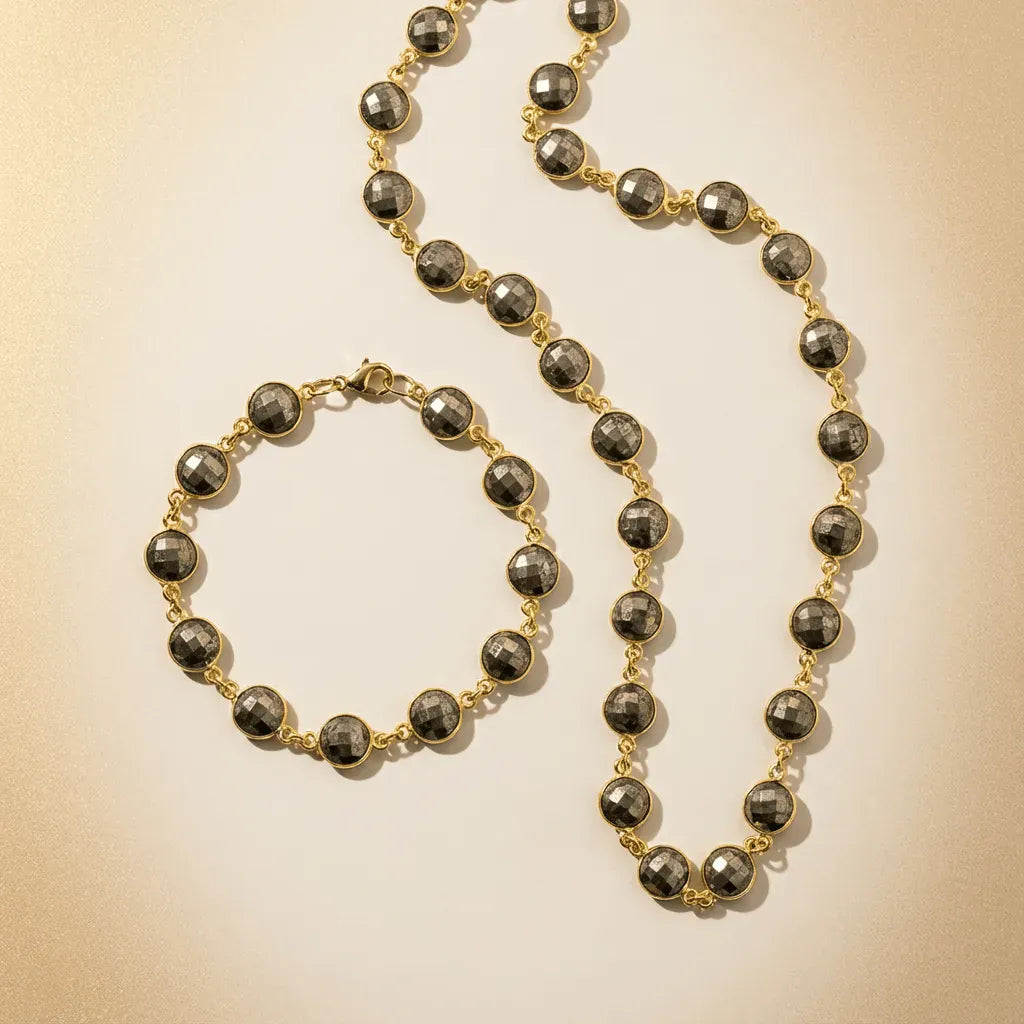 Necklace and bracelet set with black beads and gold chain on a beige background