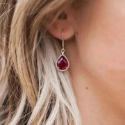 Woman wearing red exquisite teardrop earring in silver, July birthstone jewelry