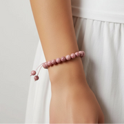 Woman wearing a rhodonite heart chakra bracelet — heart chakra jewelry for emotional balance