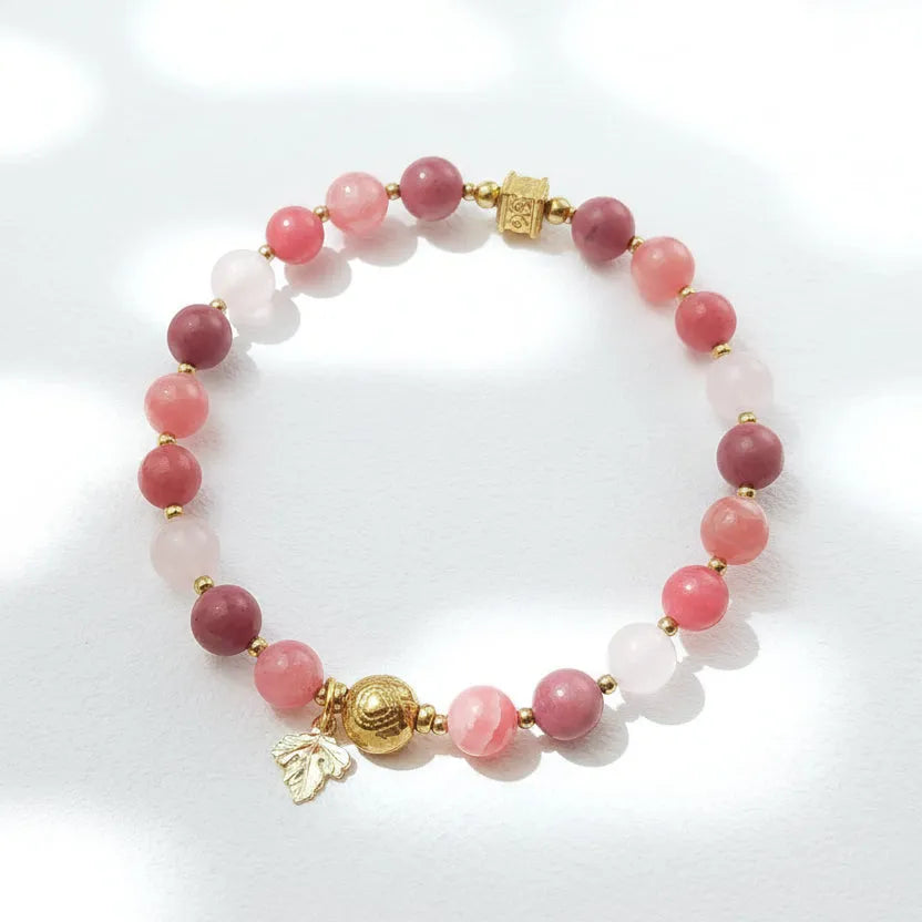 Bracelet with pink beads and gold accents on a white background