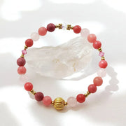 Bracelet with pink beads and gold accents on a white background