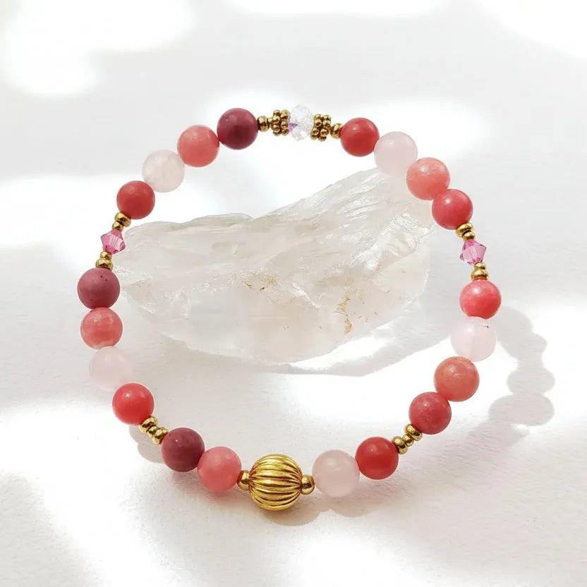 Bracelet with pink beads and gold accents on a white background