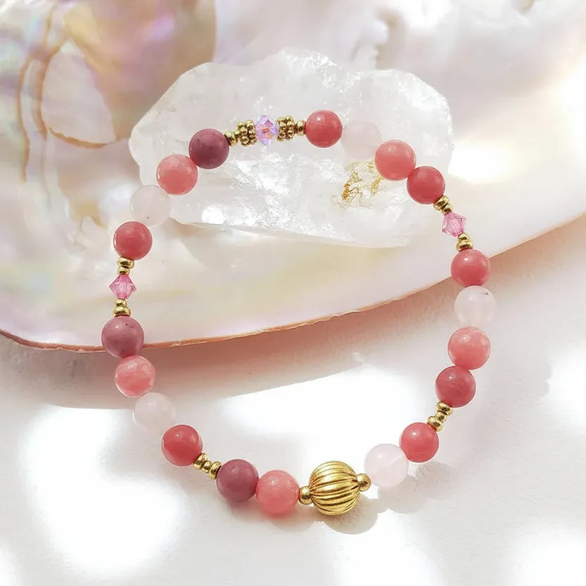 Bracelet with pink and gold beads on a shell background