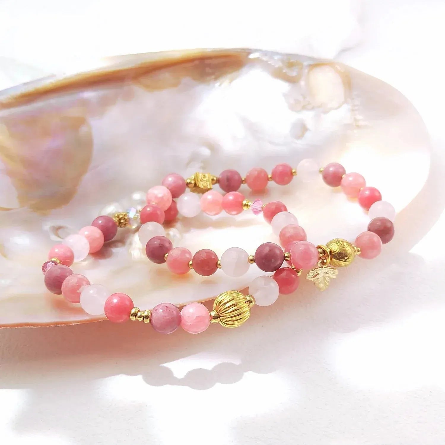 Pink and gold beaded bracelet on a shell background