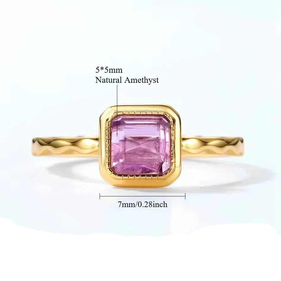 Gold ring with pink gemstone and measurement details on a white background