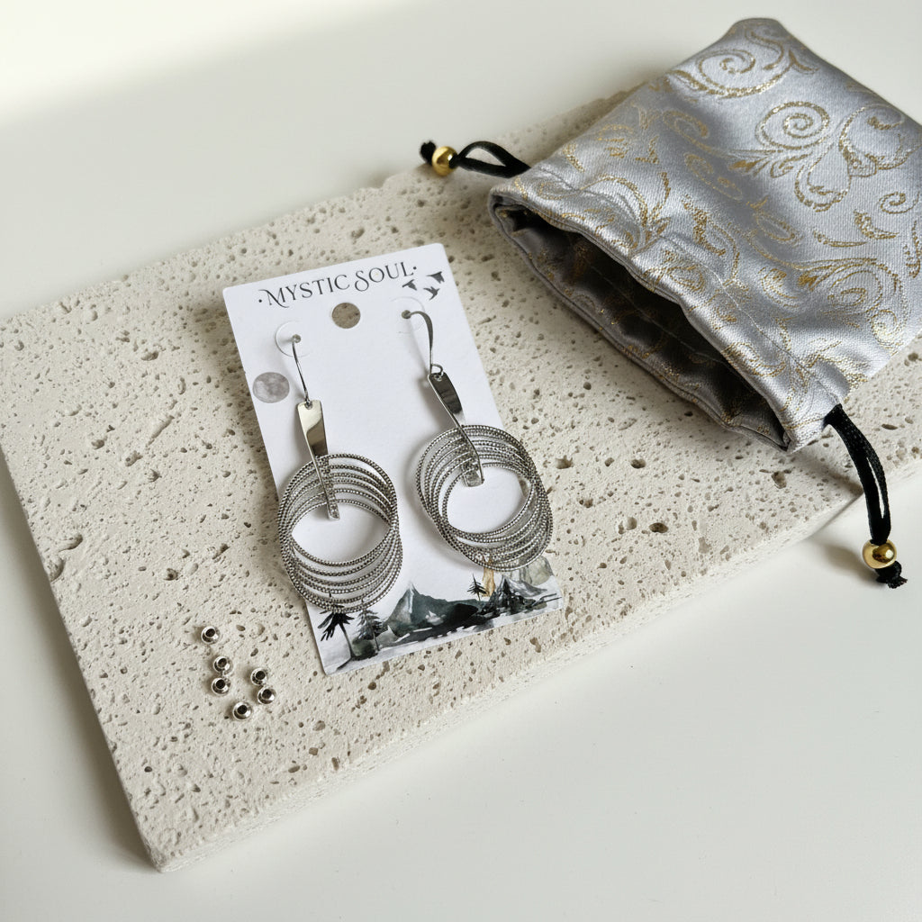 Silver plated dangle hoop statement earrings on a display card with a gift pouch